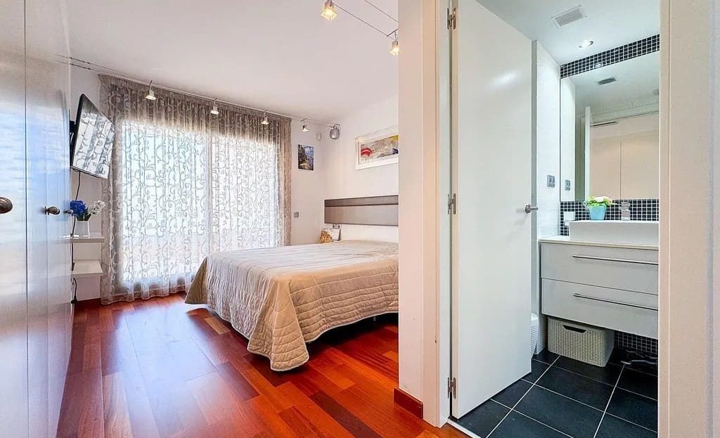 Уютная спальня с паркетным полом и встроенным шкафом в доме в Испании.