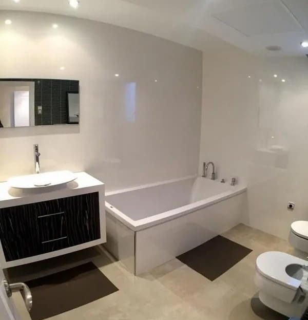 Ванная комната в современном стиле с полноценной ванной и двойной раковиной.