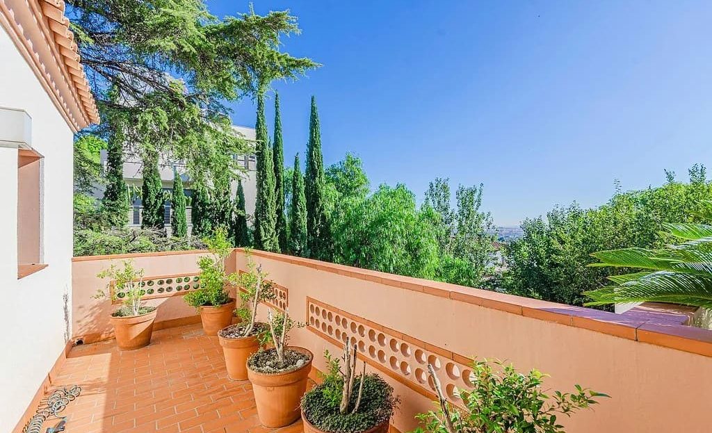 Балкон на верхнем этаже дома в Педральбес с терракотовой плиткой и видом на зелень.