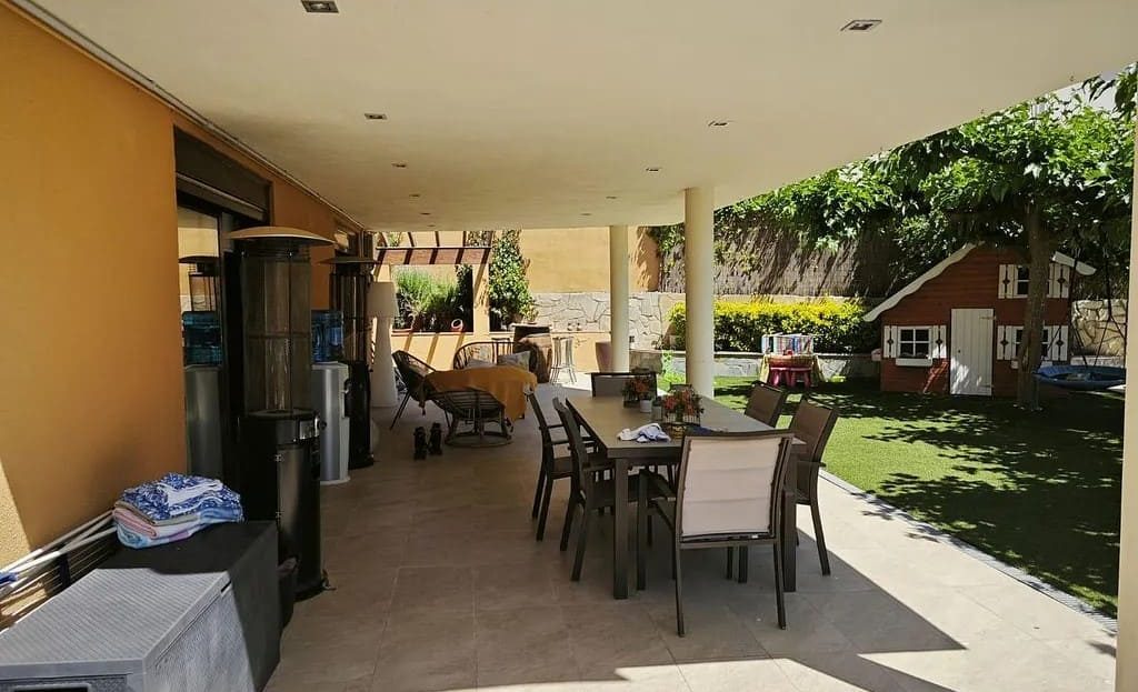 Крытая веранда дома в Испании в Эльс-Пальяресос с зоной для барбекю.