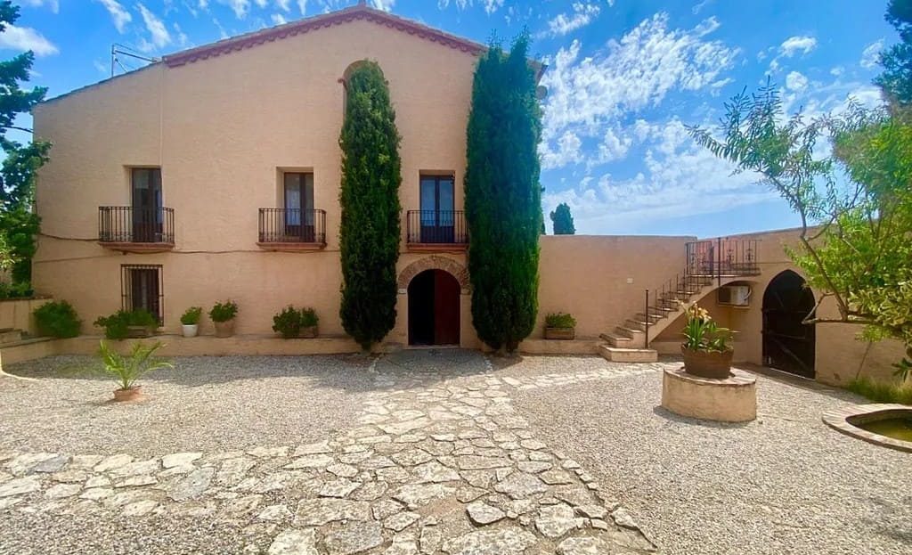 Ухоженный двор и фасад усадьбы с апартаментами для гостей при винодельне в Испании.