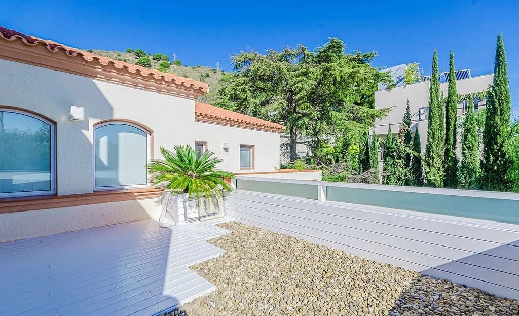 Верхняя терраса дома с гравийным покрытием и выходом из комнат.