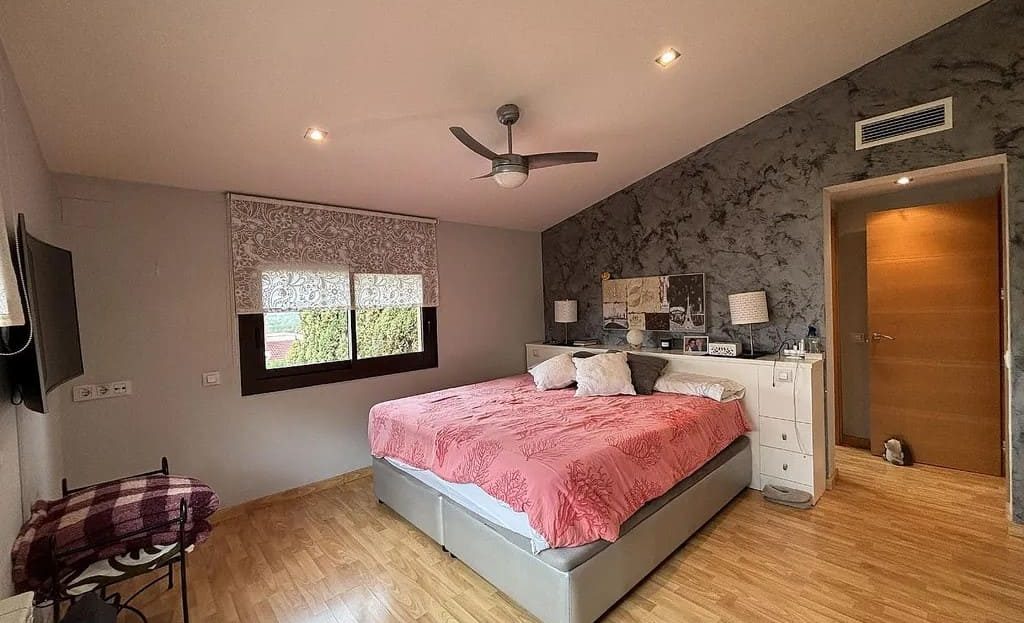 Главная спальня дома в Испании с большой кроватью и выходом в ванную комнату.