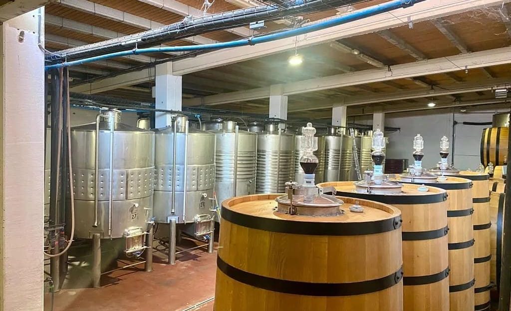 Внутренний вид цеха по производству вина с металлическими танками на винодельне в Испании.