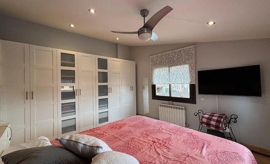 Интерьер спальни в доме в Испании со встроенными шкафами и кондиционером.