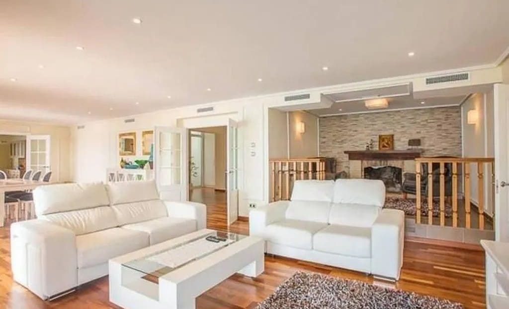 Светлая гостиная с белыми кожаными диванами и выходом на верхнюю террасу.