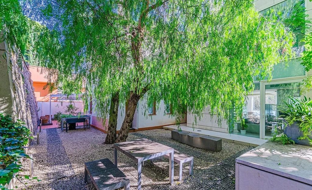 Уютный тенистый патио в задней части дома с зоной для завтраков.