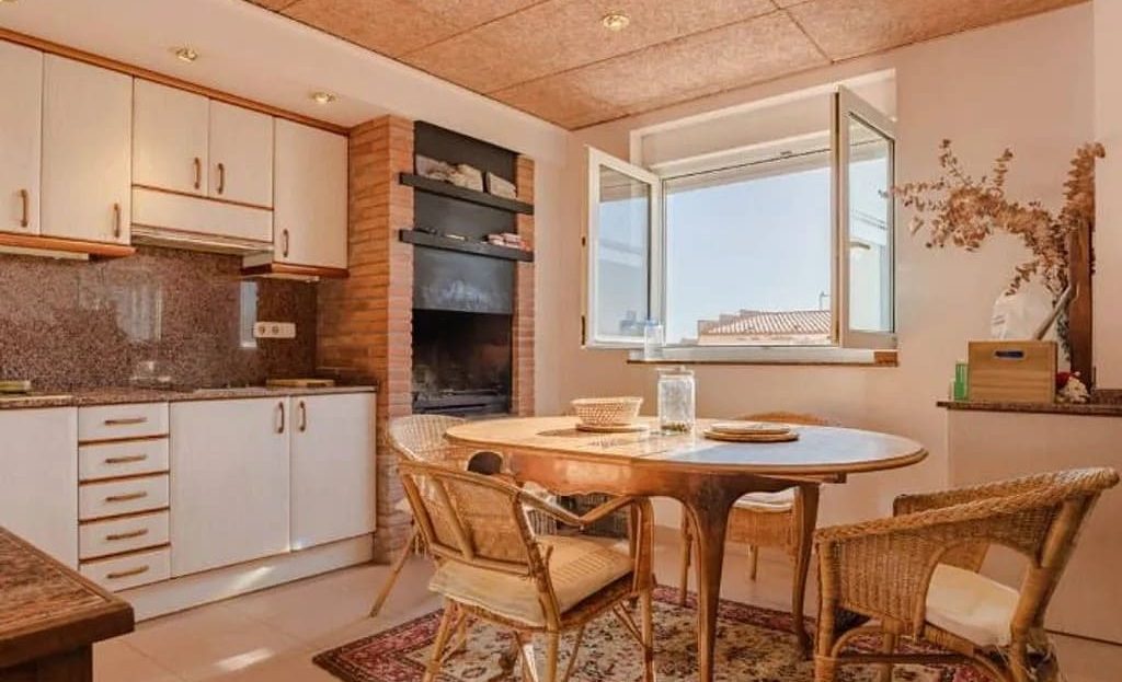 Кухня таунхауса в Таррагоне с деревянными фасадами и обеденным столом.