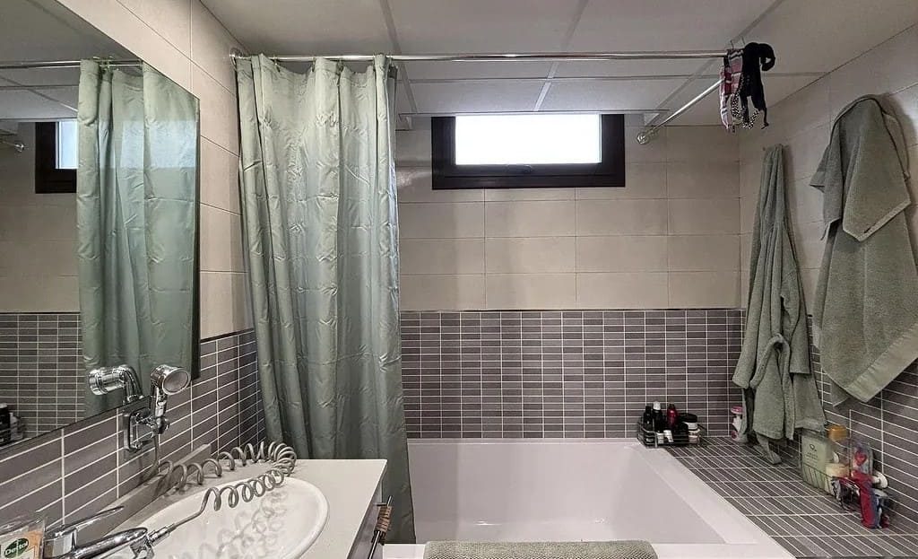 Ванная комната в доме в Испании с плиткой в серых тонах и ванной.