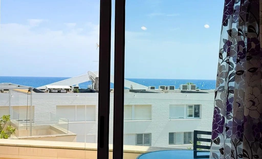 Панорамный вид на море из окна гостиной дома в Испании в Торредембарре.