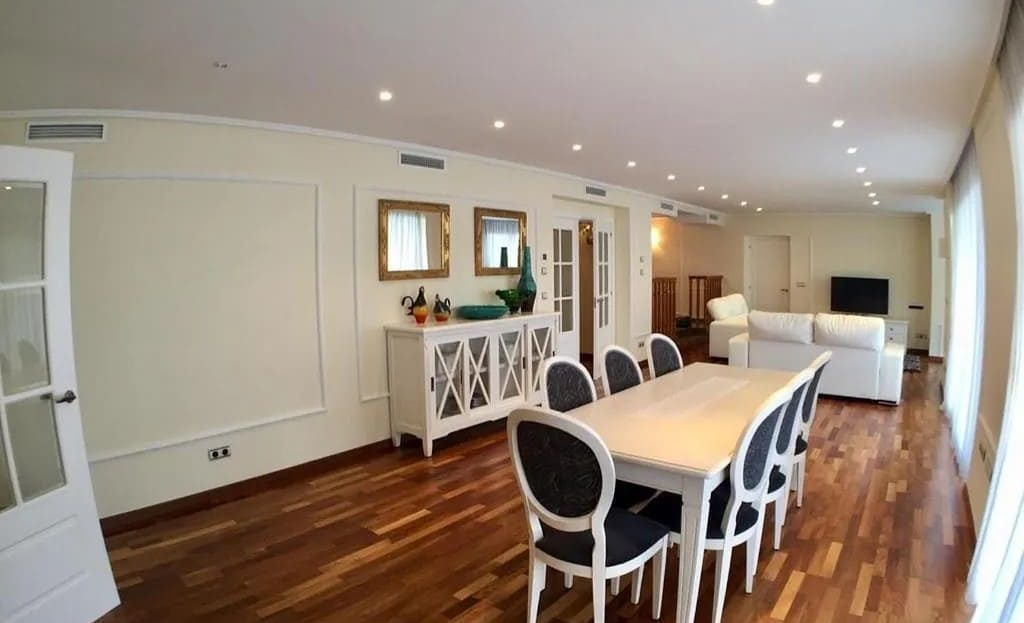 Обеденная зона в классическом стиле с массивным столом и паркетным полом.