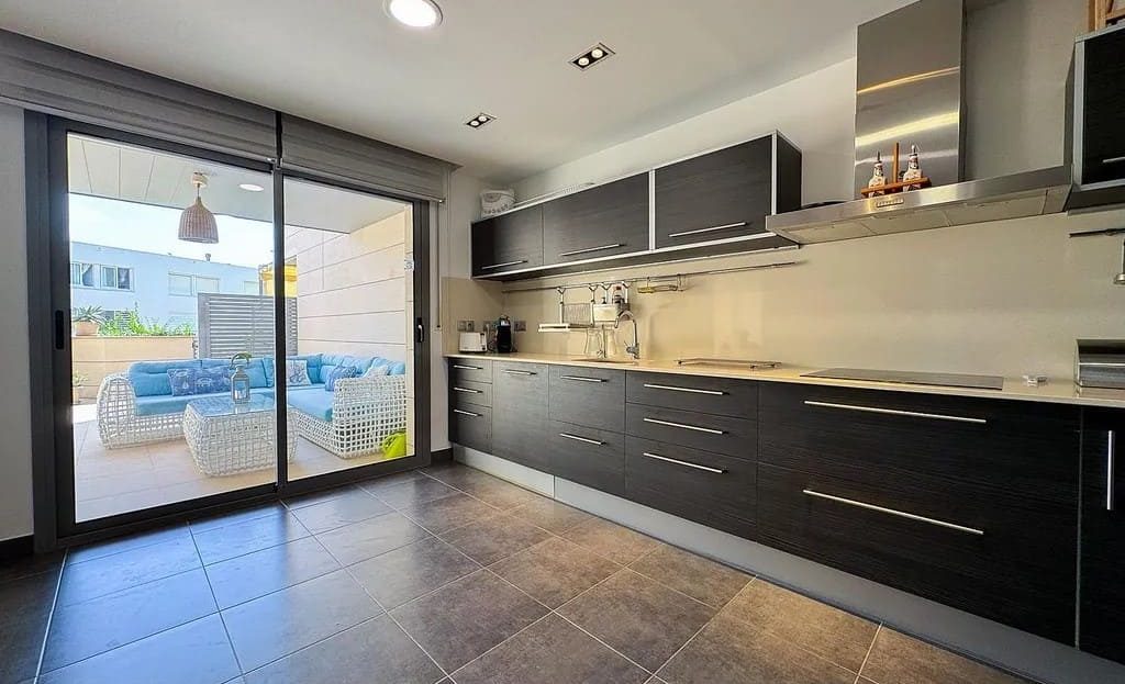 Современная кухня с выходом на террасу и видом на море в доме в Испании.